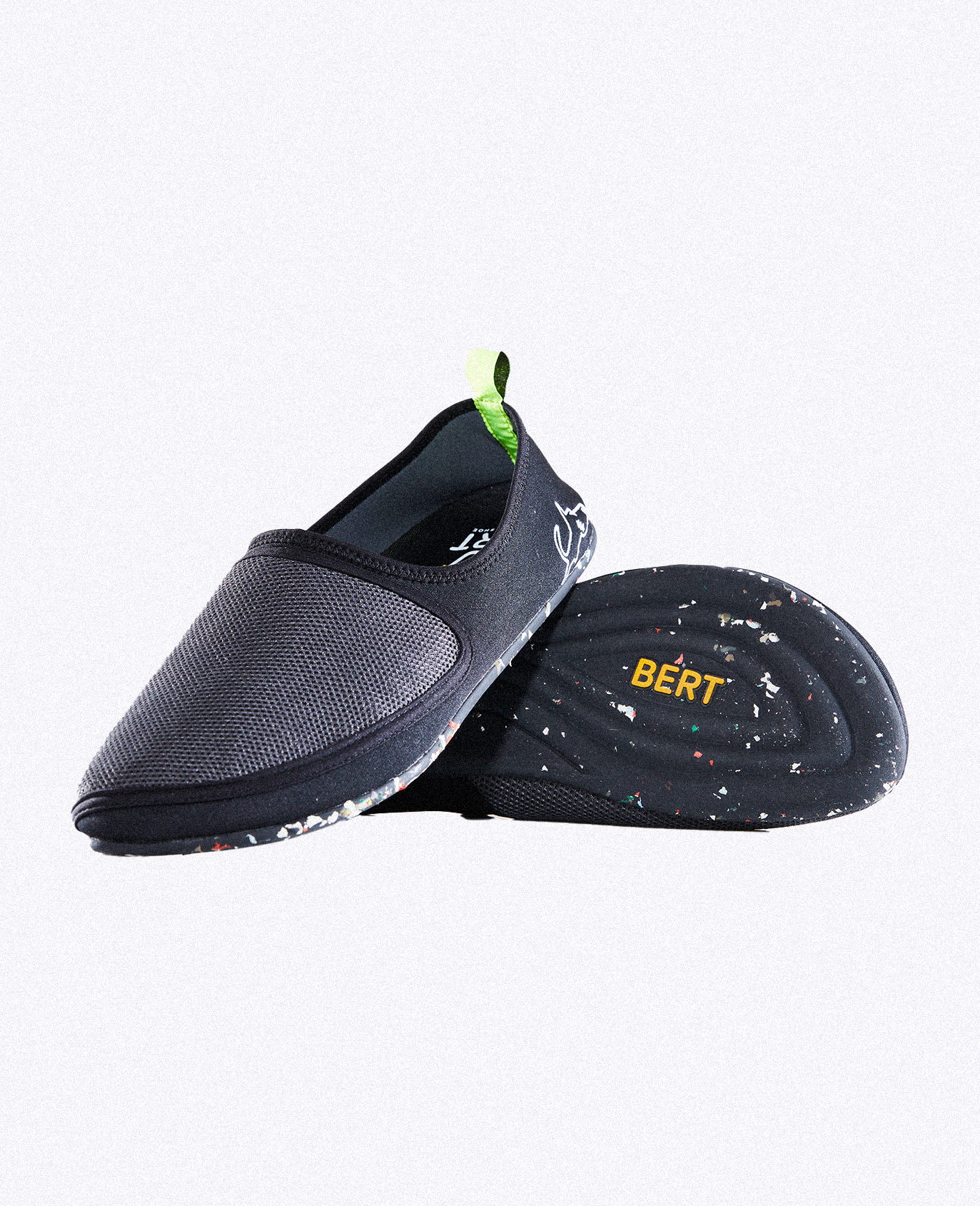 Lightweight black slip-on shoe with textured mesh upper, speckled sole, and yellow BERT logo.