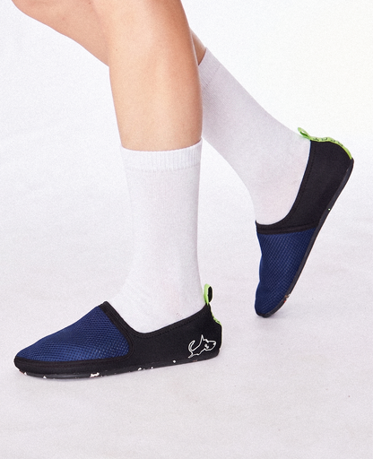 Lightweight blue and black slip-on shoes with green accents, worn with white socks