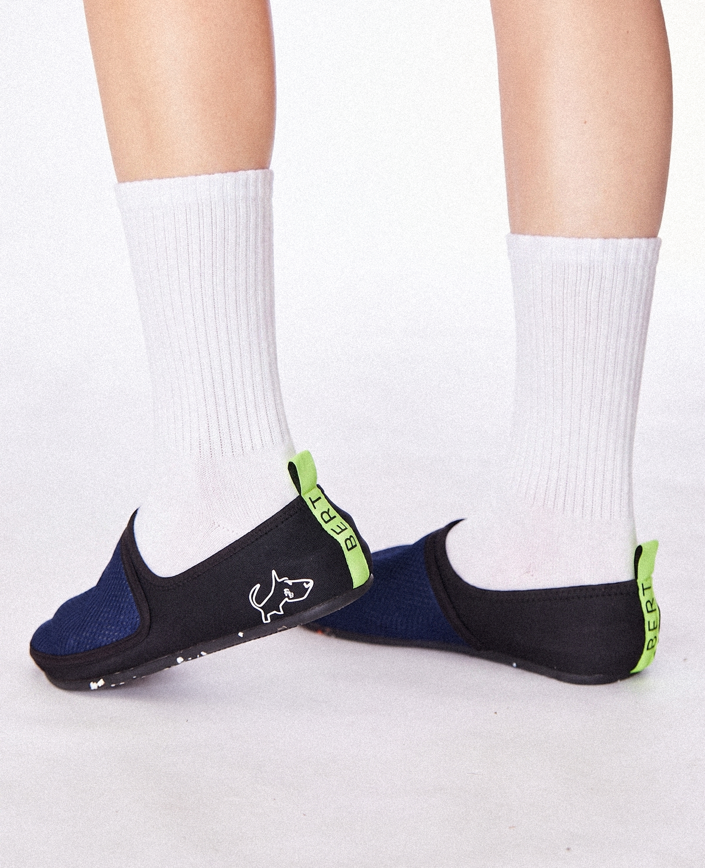 Lightweight slip-on plum shoes with dog logo, neon heel tab, worn with white socks